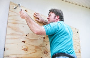 Man boarding up window